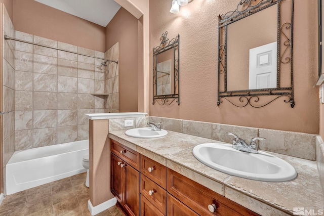 full bathroom with vanity, tiled shower / bath combo, and toilet