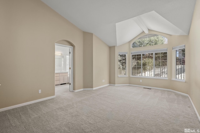 unfurnished room featuring lofted ceiling with beams and light carpet