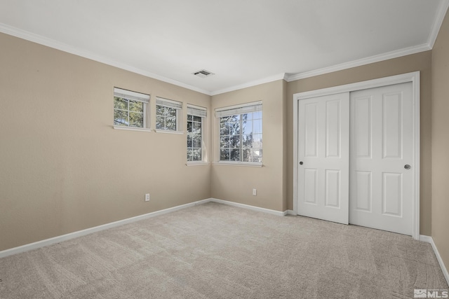 unfurnished bedroom featuring multiple windows, a closet, light carpet, and crown molding