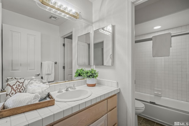 full bathroom featuring shower / bath combination with glass door, toilet, tile patterned floors, and vanity