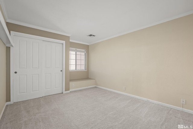 unfurnished bedroom with crown molding, a closet, and light carpet