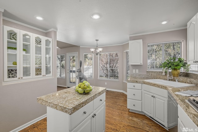 kitchen featuring decorative light fixtures, white cabinets, hardwood / wood-style flooring, and sink