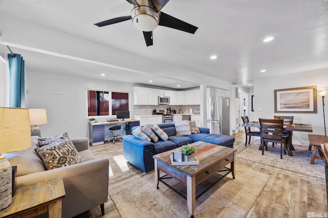 living room with ceiling fan and light wood-type flooring