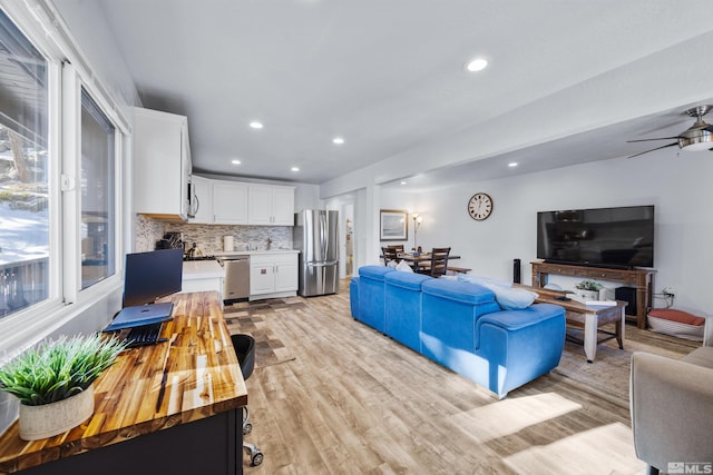 living room with ceiling fan and light hardwood / wood-style floors