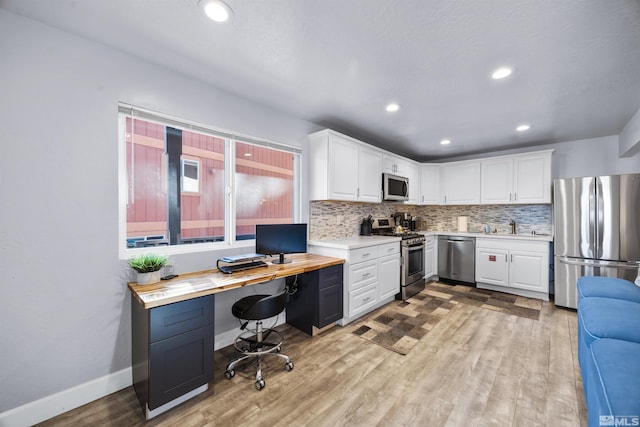 kitchen featuring light hardwood / wood-style flooring, wooden counters, white cabinetry, appliances with stainless steel finishes, and sink