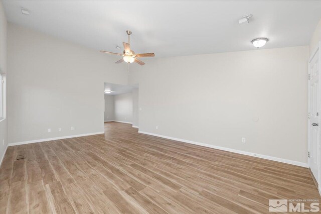 empty room with ceiling fan and light hardwood / wood-style flooring