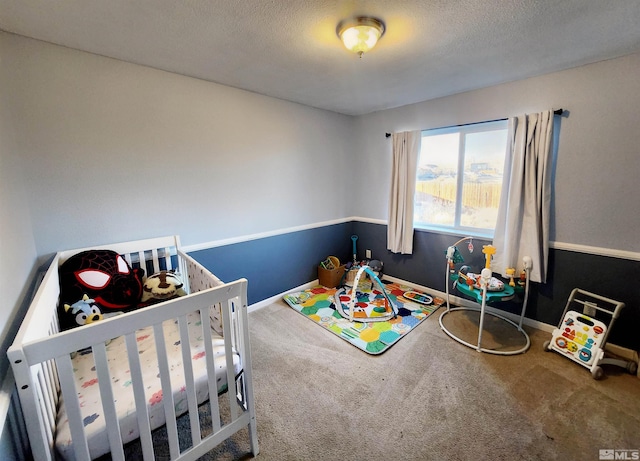 carpeted bedroom with a nursery area and a textured ceiling