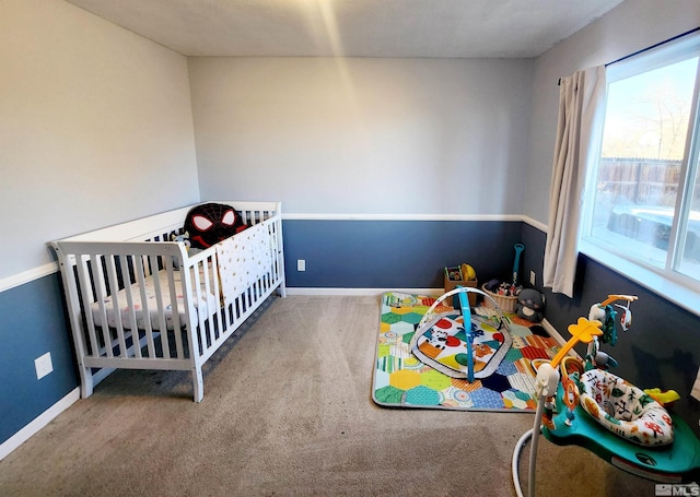 bedroom with a nursery area and carpet flooring