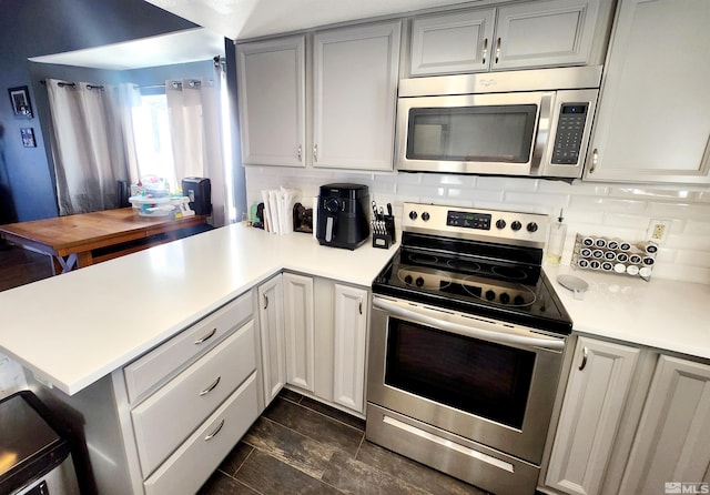 kitchen featuring tasteful backsplash, kitchen peninsula, and appliances with stainless steel finishes