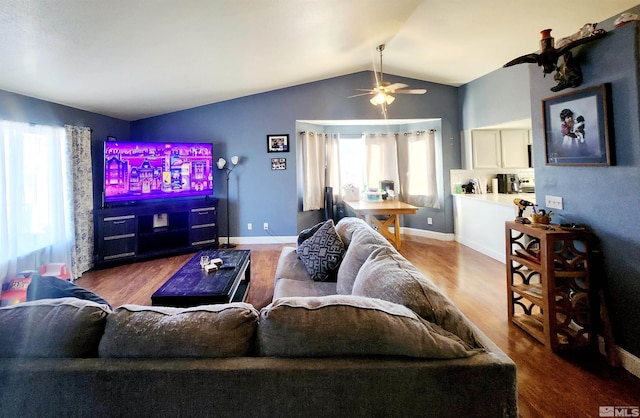 living room with ceiling fan, hardwood / wood-style floors, and vaulted ceiling