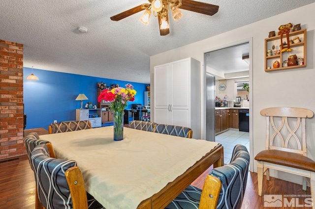 dining space with a textured ceiling, ceiling fan, and light hardwood / wood-style flooring