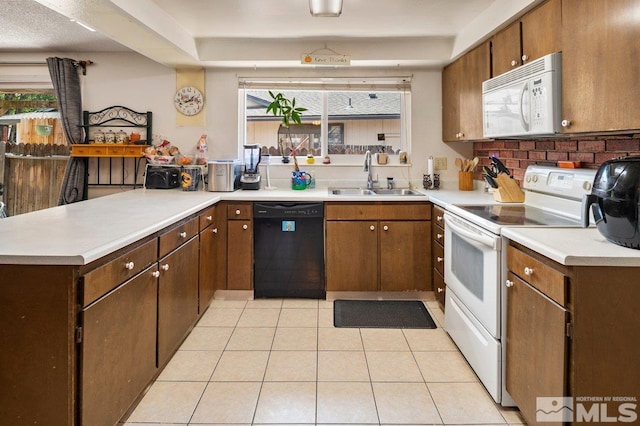 kitchen featuring white appliances, kitchen peninsula, sink, and light tile patterned floors