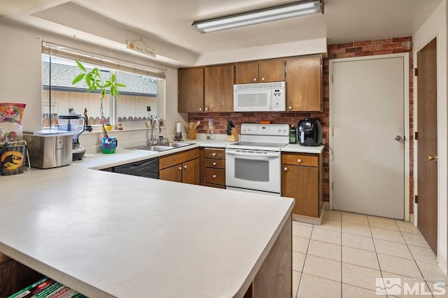 kitchen featuring sink, white appliances, light tile patterned flooring, and kitchen peninsula