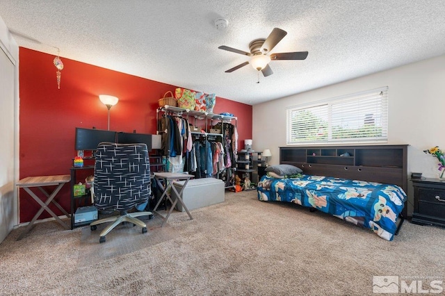 bedroom featuring ceiling fan, carpet, and a textured ceiling