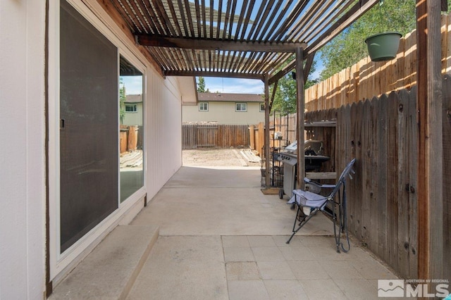 view of patio with area for grilling and a pergola