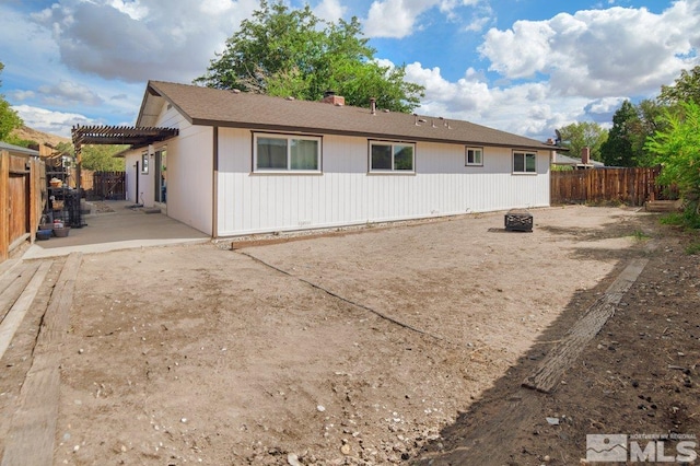 rear view of house with a fire pit, a pergola, and a patio area