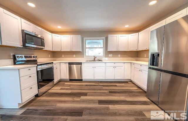 kitchen featuring sink, white cabinetry, dark hardwood / wood-style floors, and appliances with stainless steel finishes