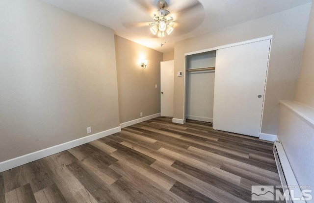 unfurnished bedroom featuring dark hardwood / wood-style flooring, a baseboard radiator, a closet, and ceiling fan