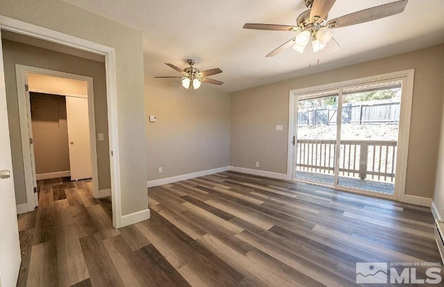 empty room with ceiling fan and dark wood-type flooring