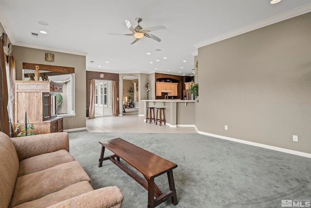 carpeted living room featuring ornamental molding and ceiling fan