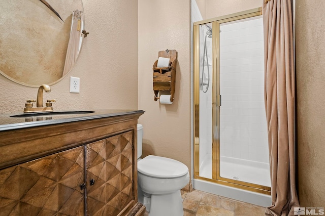 bathroom with vanity, a shower with shower door, and toilet