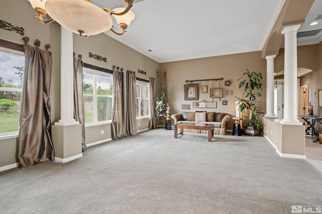 living area with an inviting chandelier, light carpet, crown molding, and decorative columns