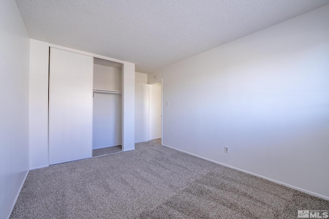 unfurnished bedroom with a closet, a textured ceiling, and carpet