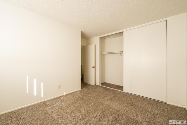 unfurnished bedroom with a textured ceiling, carpet floors, and a closet