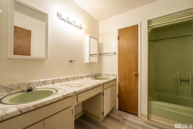 bathroom with bathing tub / shower combination, hardwood / wood-style floors, and vanity