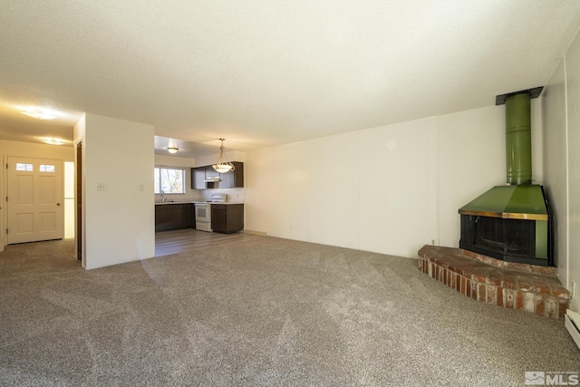 unfurnished living room featuring sink, carpet floors, and a textured ceiling