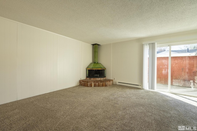 unfurnished living room featuring wooden walls, baseboard heating, a wood stove, and carpet flooring