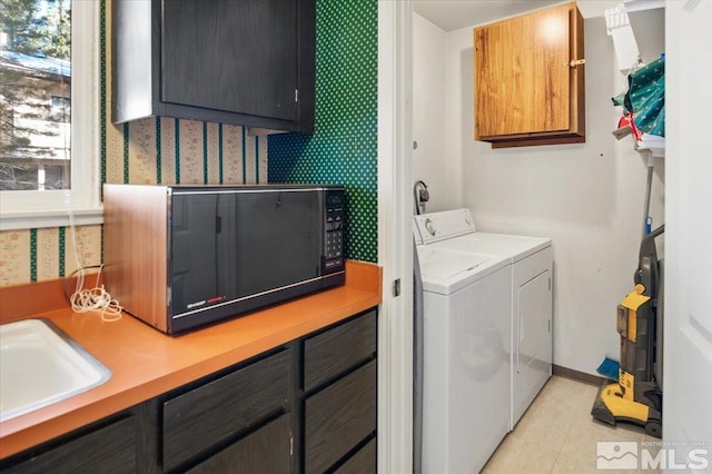 laundry room featuring independent washer and dryer, cabinets, light tile patterned floors, and sink