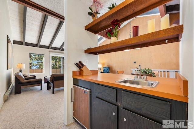 kitchen featuring sink, light colored carpet, lofted ceiling with beams, and a baseboard radiator