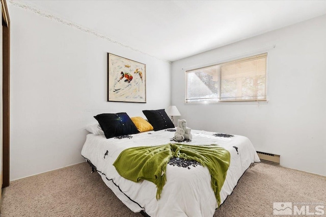 bedroom with a baseboard heating unit and light colored carpet