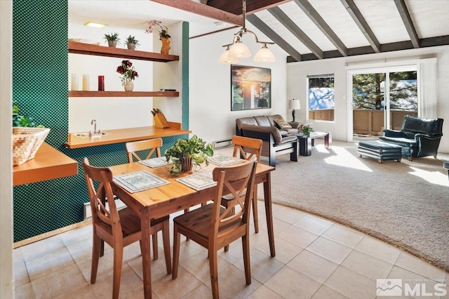 dining space featuring sink, light colored carpet, lofted ceiling with beams, and a baseboard heating unit