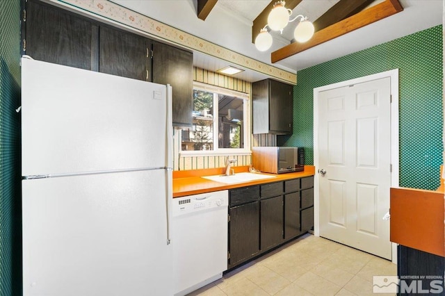 kitchen featuring white appliances, dark brown cabinets, and sink