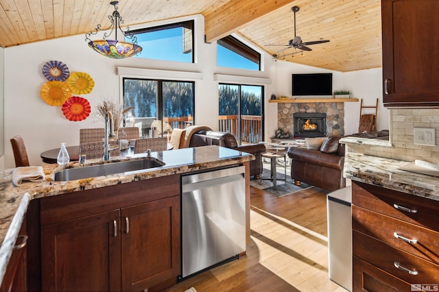 kitchen with a stone fireplace, vaulted ceiling with beams, sink, stainless steel dishwasher, and backsplash