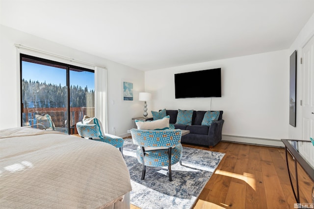 bedroom with baseboard heating and hardwood / wood-style floors