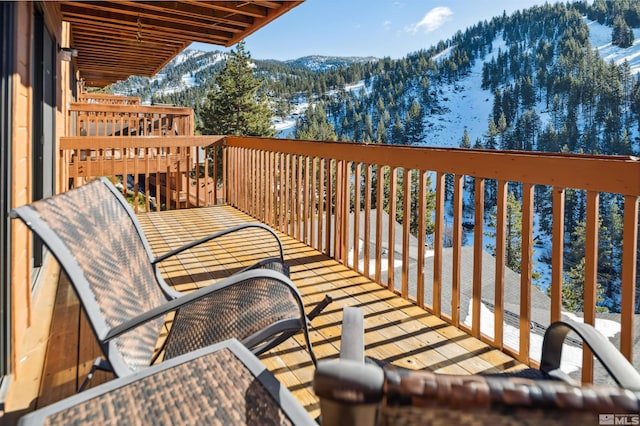 snow covered back of property featuring a mountain view