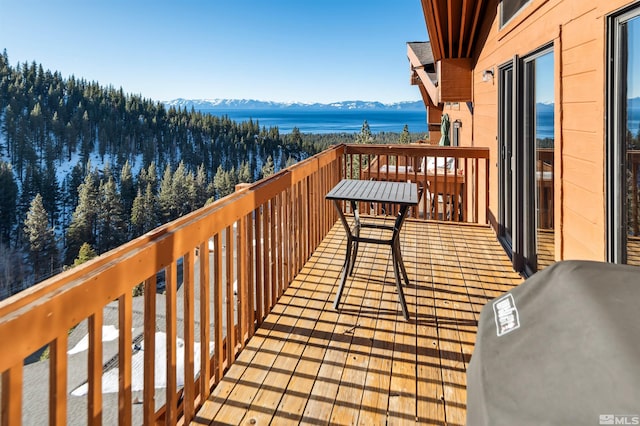 balcony featuring a water and mountain view and grilling area