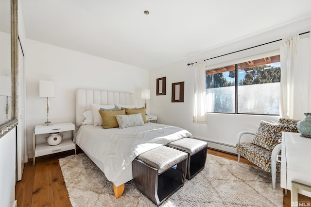 bedroom with a baseboard radiator and wood-type flooring