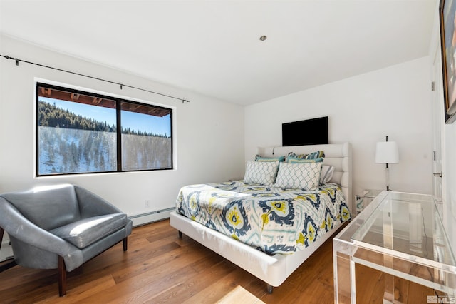 bedroom featuring hardwood / wood-style flooring and a baseboard radiator