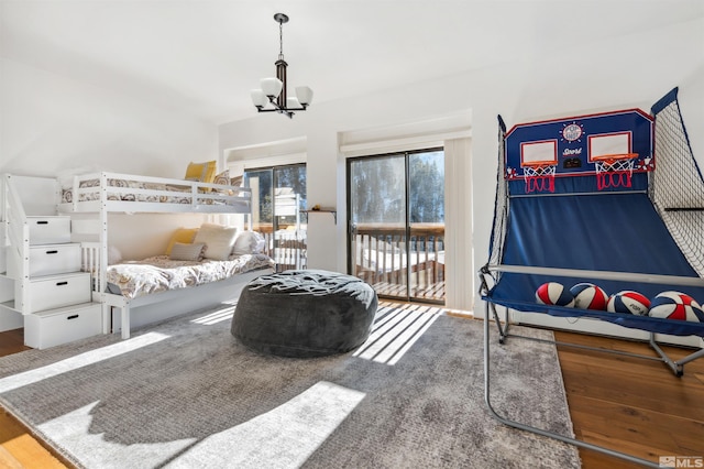 bedroom with hardwood / wood-style flooring and an inviting chandelier