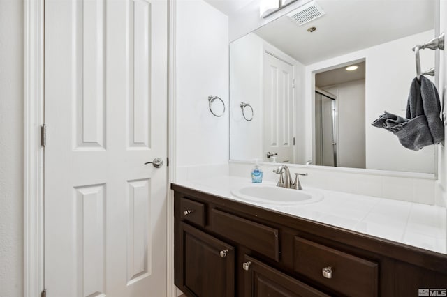 bathroom with vanity and a shower with shower door