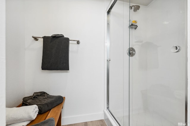 bathroom featuring a shower with door and wood-type flooring