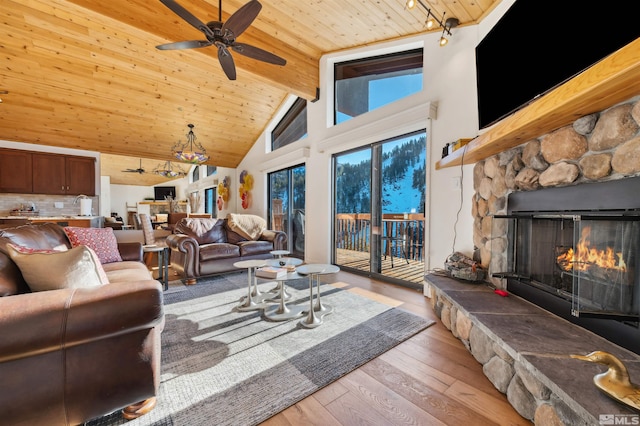 living room with wooden ceiling, a fireplace, ceiling fan, light hardwood / wood-style floors, and high vaulted ceiling