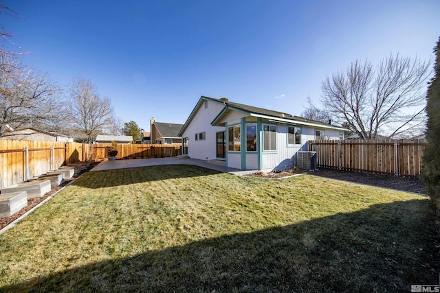 rear view of house with central AC and a yard