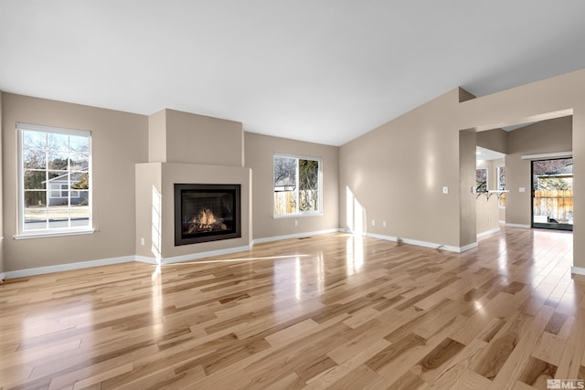 unfurnished living room featuring light hardwood / wood-style floors and vaulted ceiling