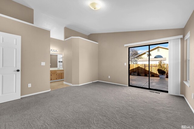 interior space with vaulted ceiling and light colored carpet