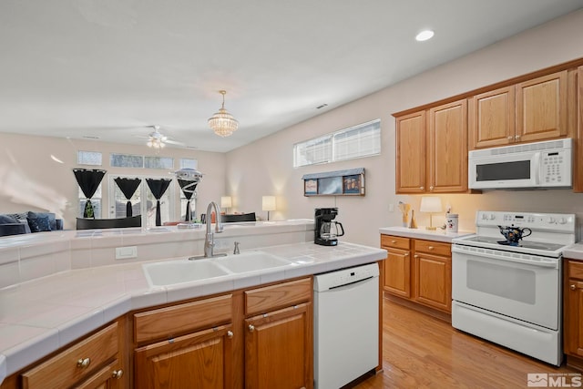 kitchen featuring sink, white appliances, ceiling fan, and tile counters